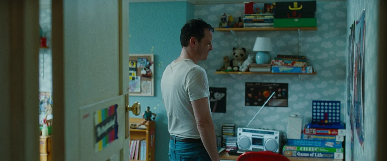 All Of Us Strangers (2023) movie still: medium — A small child's room with light blue patterned wallpaper is filled with toys and games. A man…