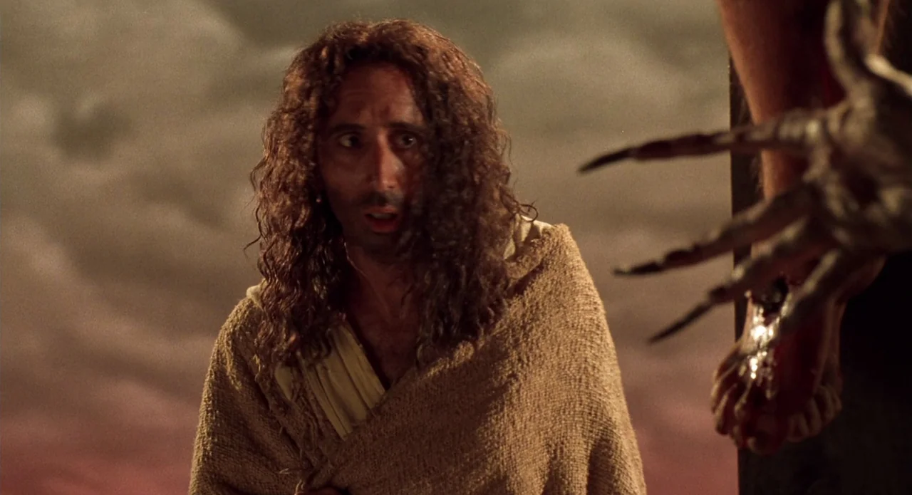 Tales from the Crypt: Demon Knight (1995) movie still: medium — A dark, atmospheric setting with swirling smoky clouds under a night sky. A man in…