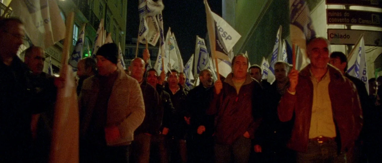 Arabian Nights: Volume 3 The Enchanted One (2015) movie still: medium — A crowd of men walks through a city street at night holding white banners.…
