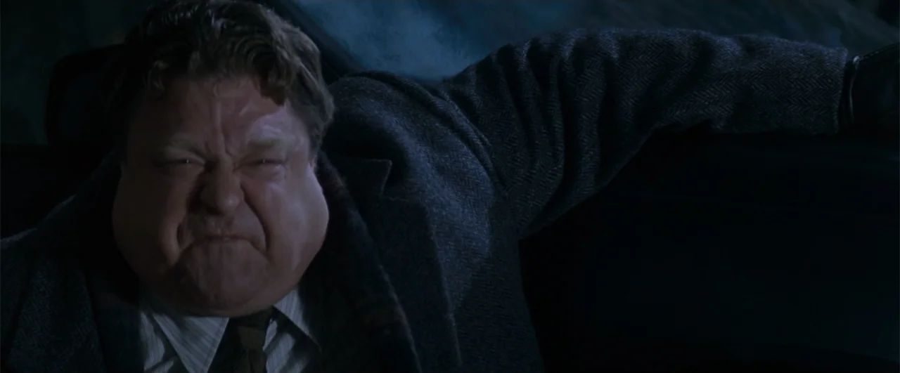 Fallen (2004) movie still: medium — The interior of a dark car at night reveals a man in a wool coat. He leans across the seat with his arm extended…