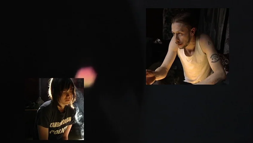 The Tracey Fragments (2007) movie still: medium — Two separate framed vignettes show individuals in a dark room against black voids. A man in a tank…