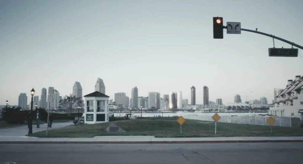 My Son, My Son, What Have Ye Done? (2009) movie still: wide — A quiet urban waterfront area features a grassy park with a small booth structure. A…