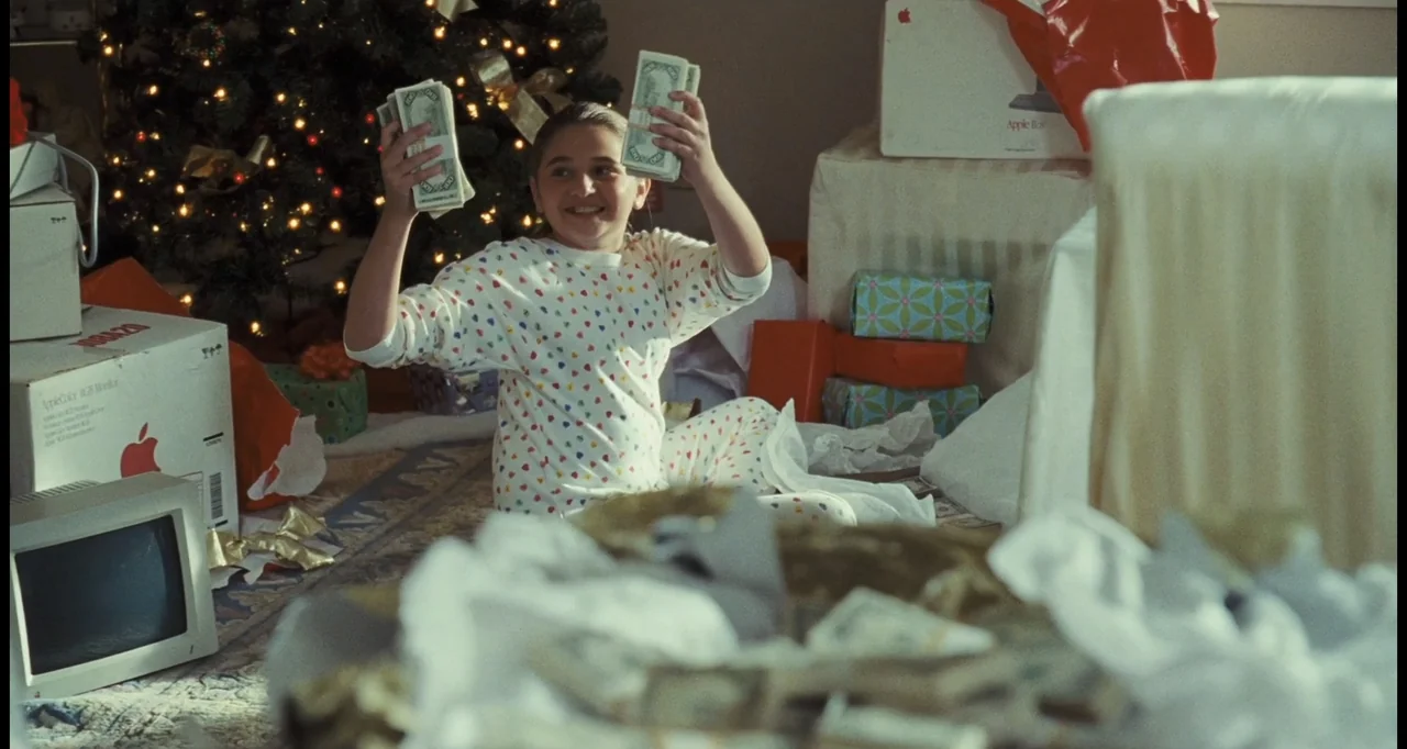 I Love You Phillip Morris (2010) movie still: medium — A residential room features a decorated Christmas tree and scattered gift boxes. A young girl…