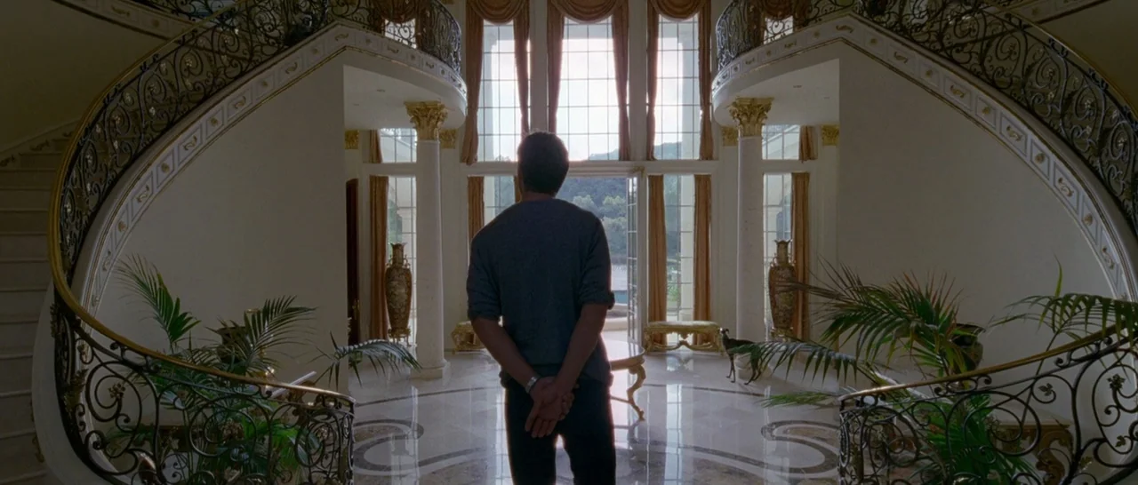 Song to Song (2017) movie still: fullbody — A spacious foyer features dual curved staircases and a polished marble floor. A man stands in the center…