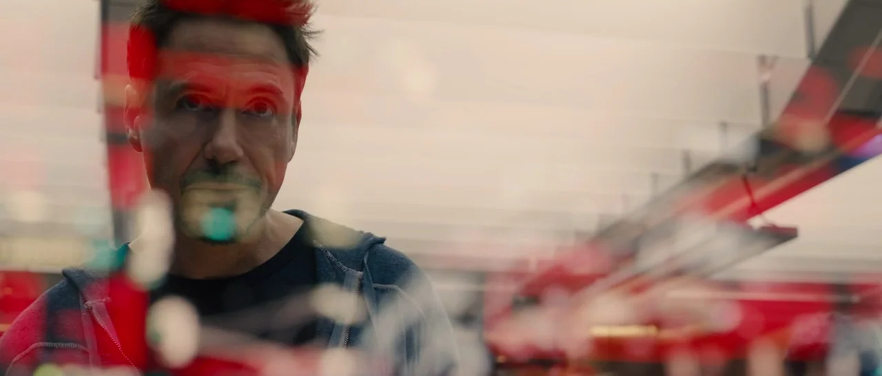 Avengers: Age of Ultron (2015) movie still: closeup — A man is positioned behind a reflective glass surface within a sterile technical space. He…