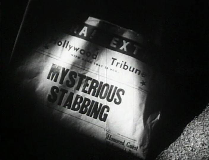 Dementia (Daughter of Horror) (1955) movie still: closeup — A vintage newspaper lies in a dark, shadow-filled environment. A tight beam of light…