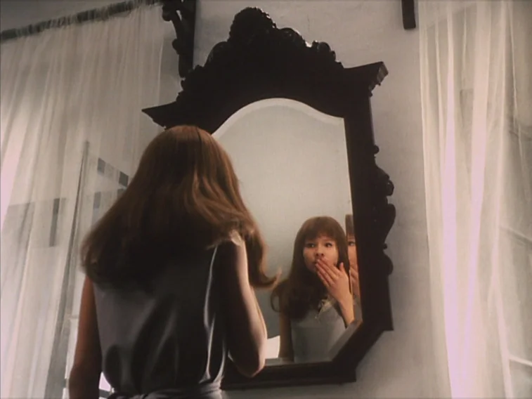 Valerie & Her Week of Wonders (1970) movie still: medium — A room with white walls and draped sheer curtains frames a decorative dark wooden mirror.…