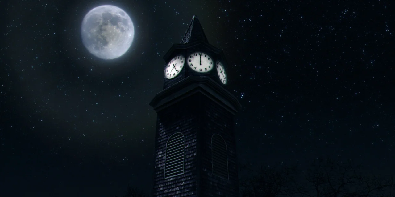 Twixt (2011) movie still: wide — A tall wooden clock tower rises against a dark, starry night sky with a full moon. The clock faces are lit from…