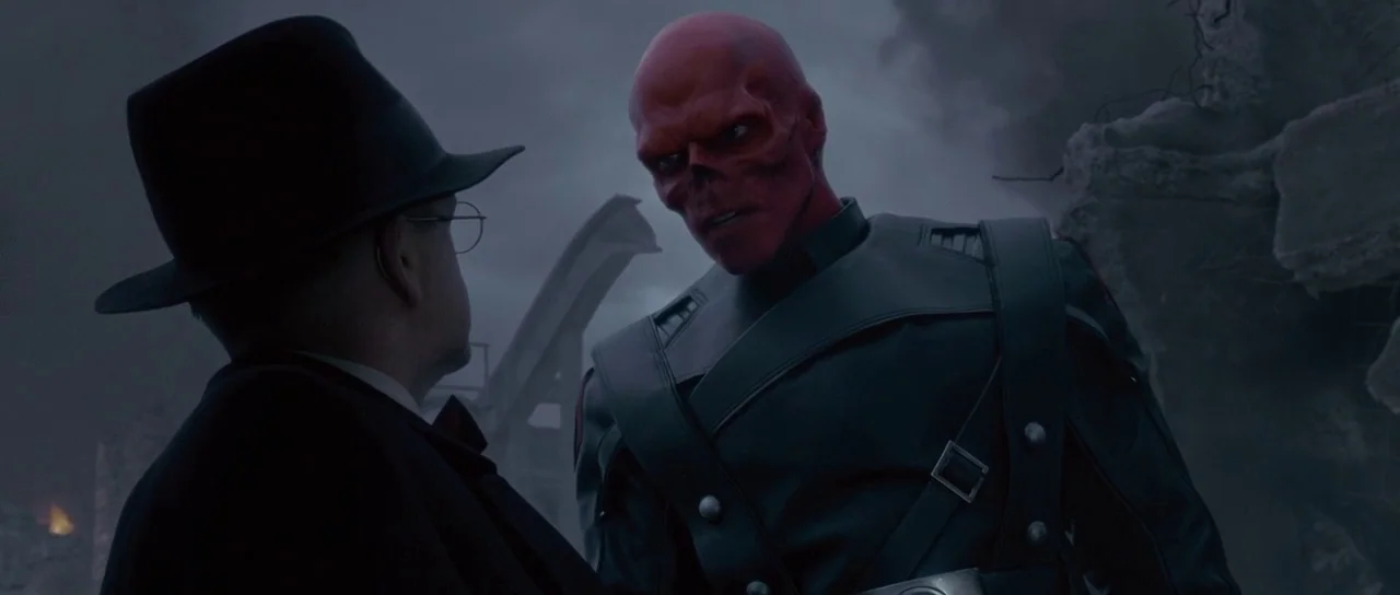 Captain America: The First Avenger (2011) movie still: medium — A destroyed urban landscape under a cloudy grey sky with rubble and fire visible. A…
