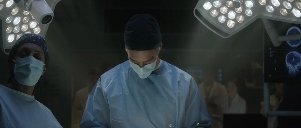 Doctor Strange (2016) movie still: medium — A dimly lit hospital operating room with high-intensity surgical lights illuminating the central…