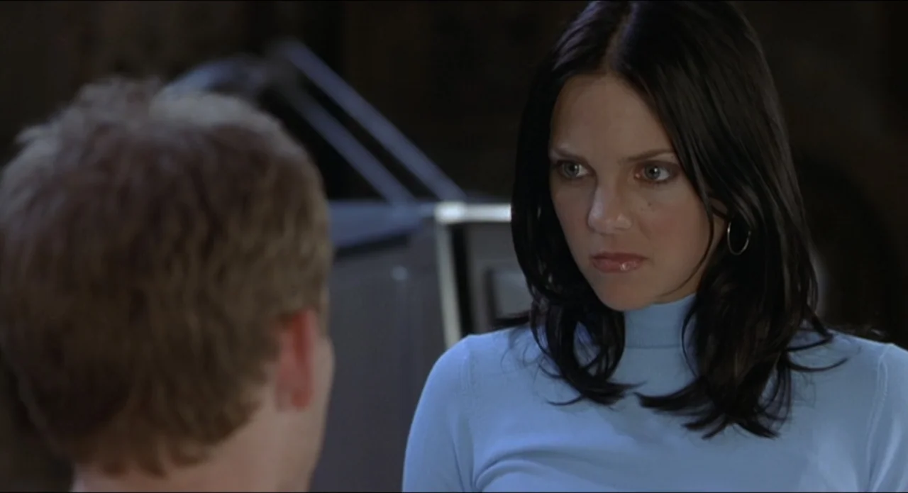 Scary Movie 2 (2001) movie still: medium — An indoor setting with dark neutral tones forms the background behind two people. A woman with dark hair…