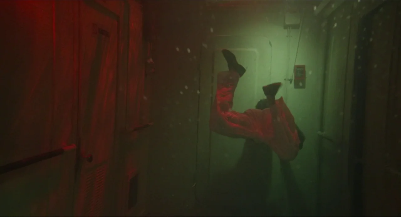 Life of Pi (2012) movie still: medium — An industrial corridor filled with water illuminated by red and green emergency lights. A person is floating…