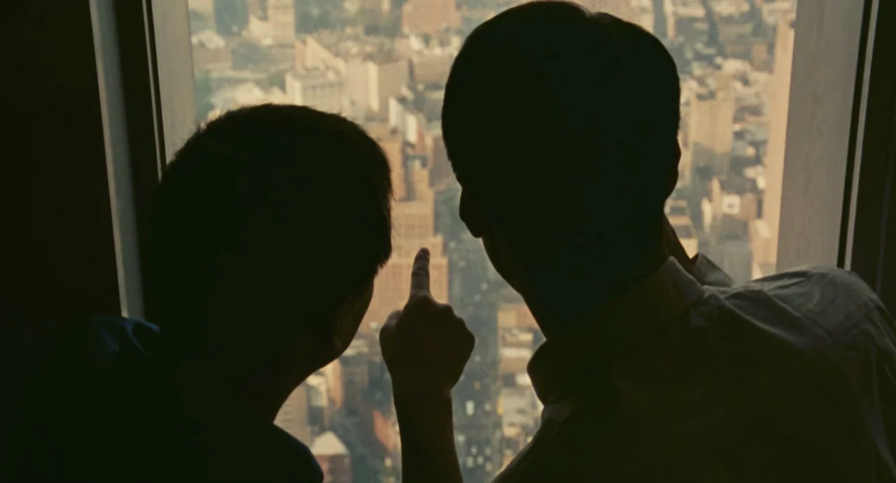 Comrades: Almost A Love Story (1996) movie still: medium — A high-rise observation level with a floor-to-ceiling glass window looking over a dense…