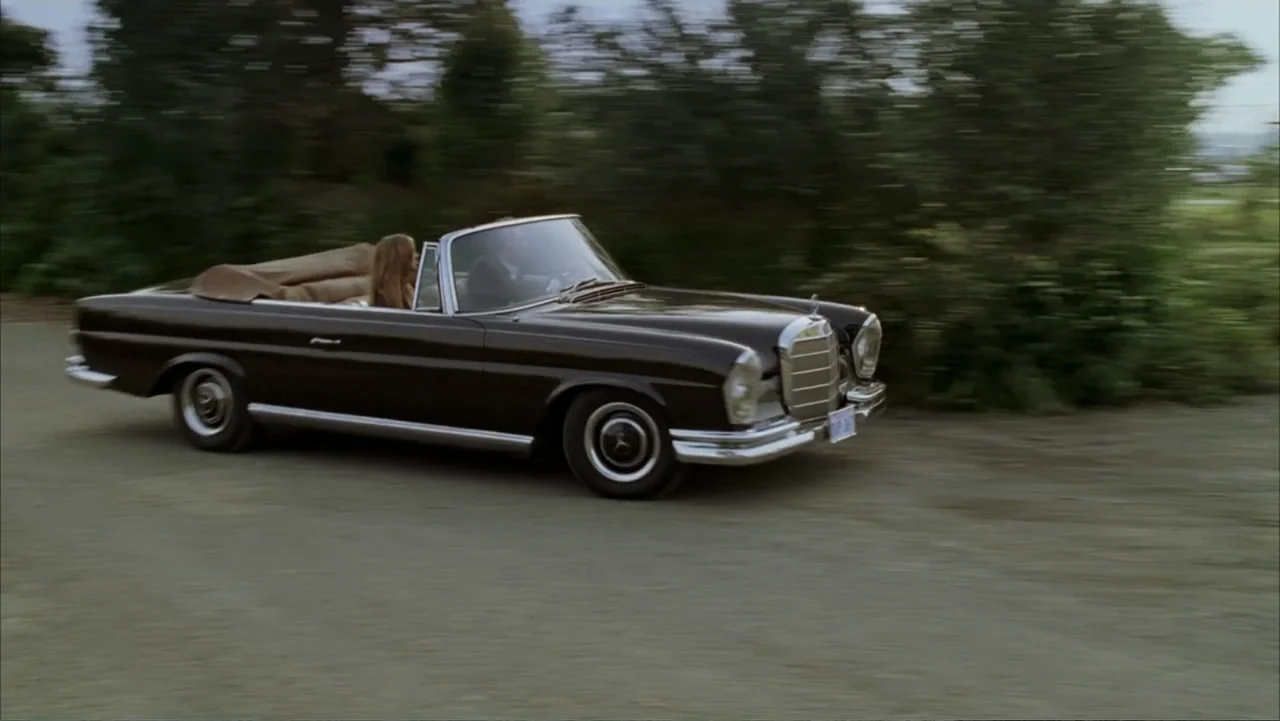 Rumor Has It... (2005) movie still: wide — A vintage black Mercedes convertible travels along a gravel road lined with trees. Two occupants are…