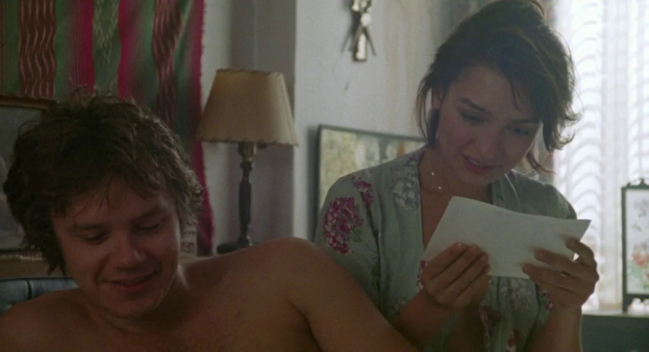 Jacob’s Ladder (1990) movie still: medium — A sunlit room features patterned textiles and a lamp visible against a white wall. A woman in a floral…