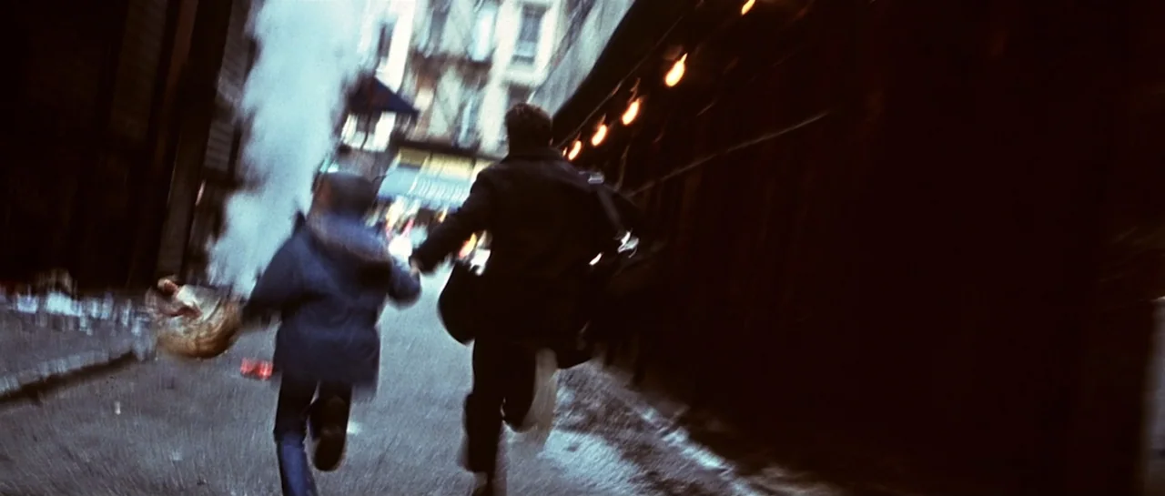 Don't Say a Word (2001) movie still: fullbody — A narrow urban alleyway with dark walls and scattered steam at night. A man and a young child are…