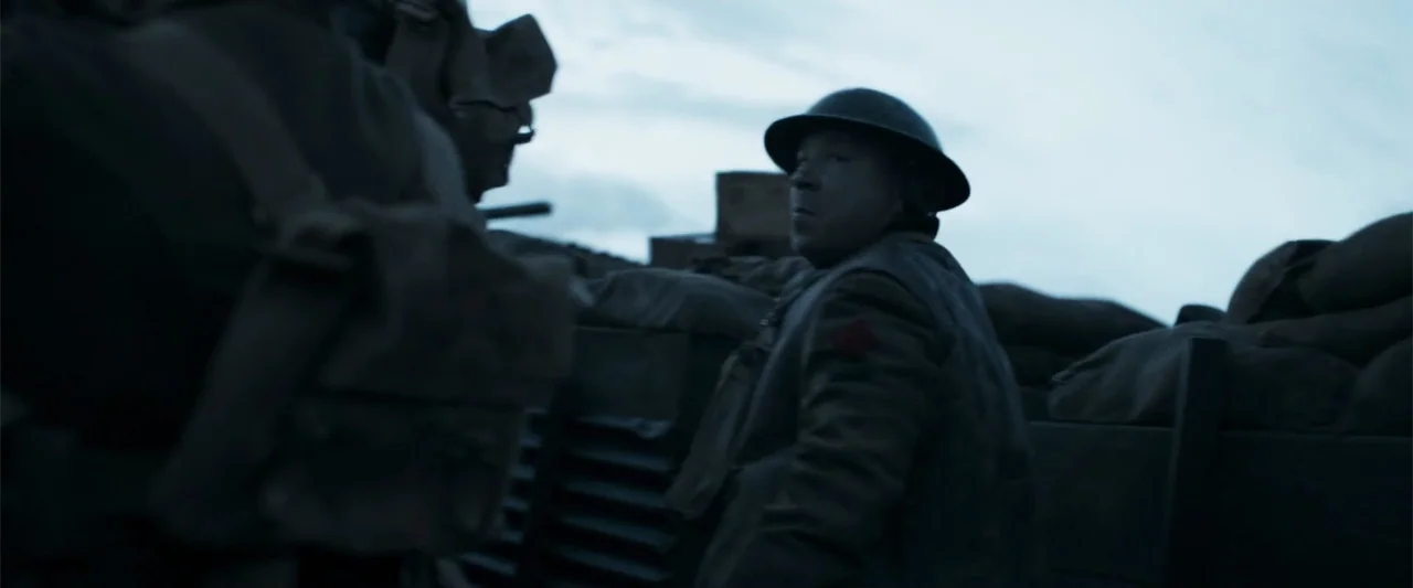 Gone Missing -  Old John's Final Journey (2014) movie still: medium — A muddy trench line features stacked sandbags under a grey overcast sky. A…
