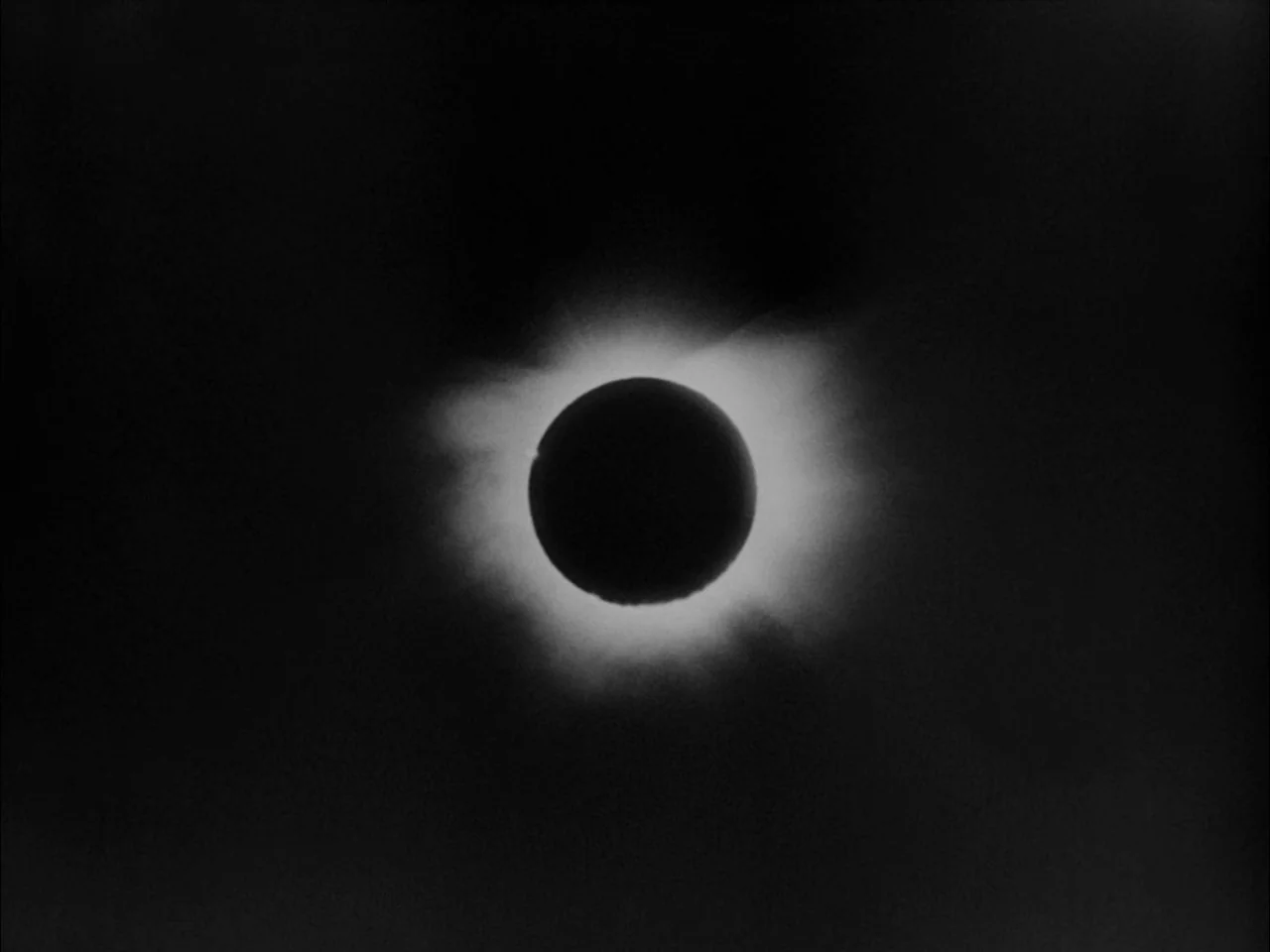 The Sun In A Net (1963) movie still: establishing — A total solar eclipse is visible against a vast black background of space. The moon blocks the…