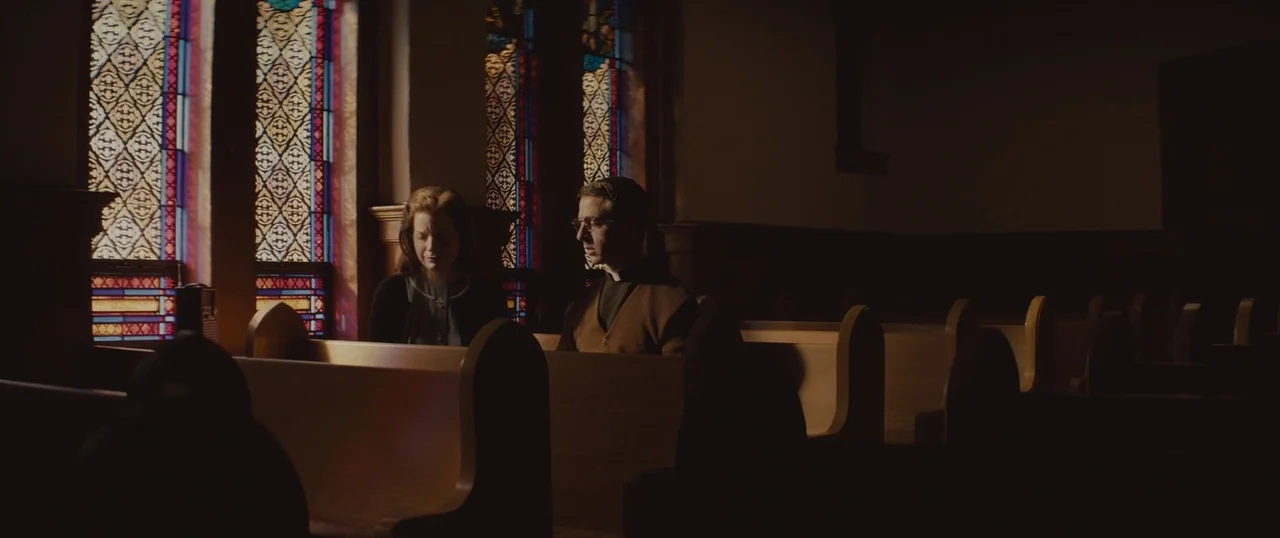 Selma (2014) movie still: medium — A quiet church interior features rows of wooden pews and tall, intricate stained glass windows. A woman and a…