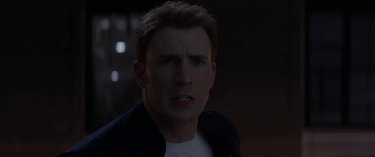 Captain America: The Winter Soldier (2014) movie still: closeup — The subject stands in a darkened urban environment at night. He is shown from the…