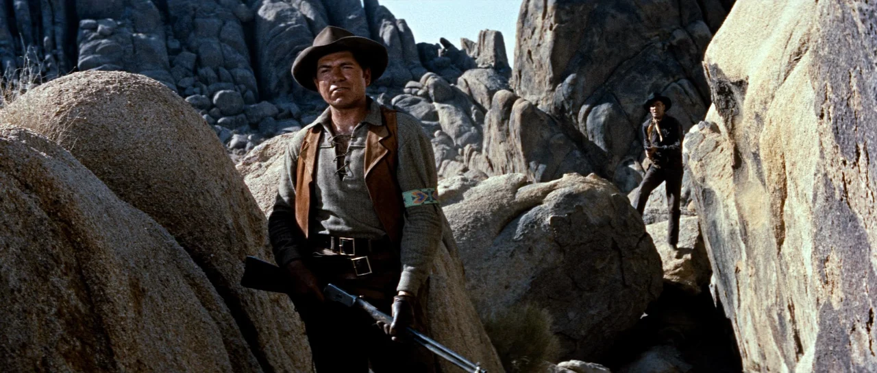 Comanche Station (1960) movie still: medium — A rugged desert landscape features massive rounded granite boulders and jagged rock formations. Two…