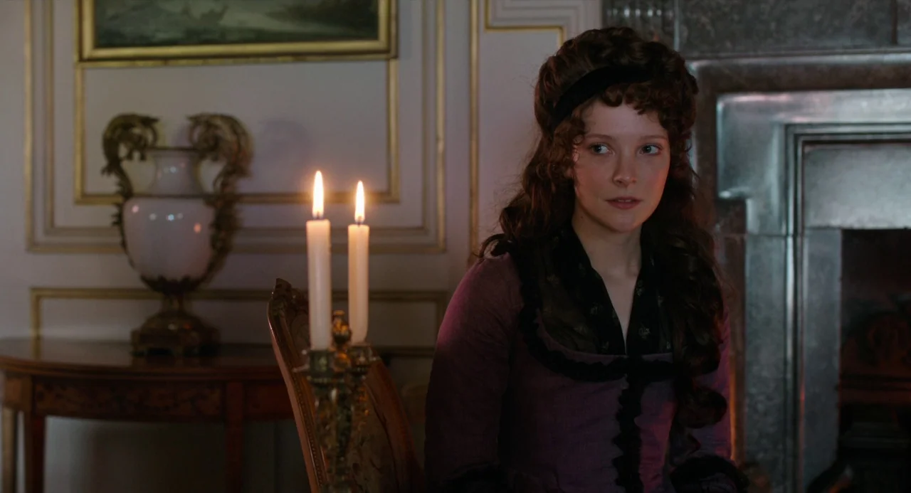 Love and Friendship (2016) movie still: medium — An opulent 19th-century room features ornate wall molding, a fireplace, and fine furniture. A young…