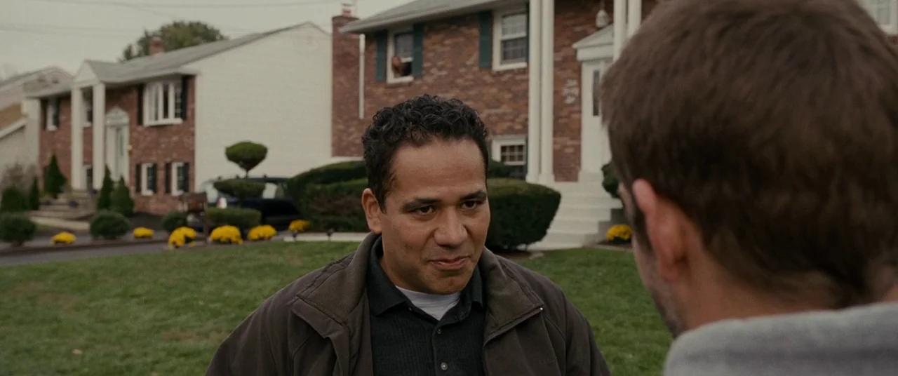 Silver Linings Playbook (2012) movie still: medium — A suburban front yard features a well-manicured green lawn and brick houses in background. A…