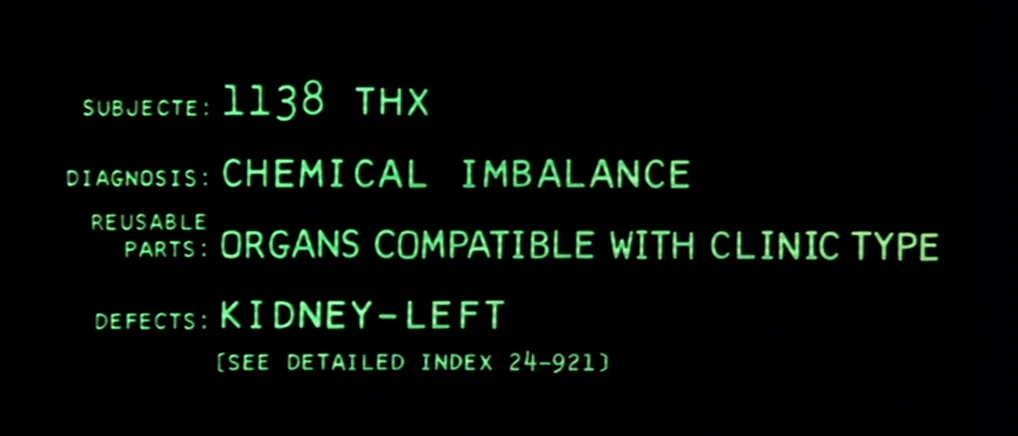 THX 1138 (1971) movie still: closeup — A computer display shows medical data in bright green monospace font against black. The text lists details…