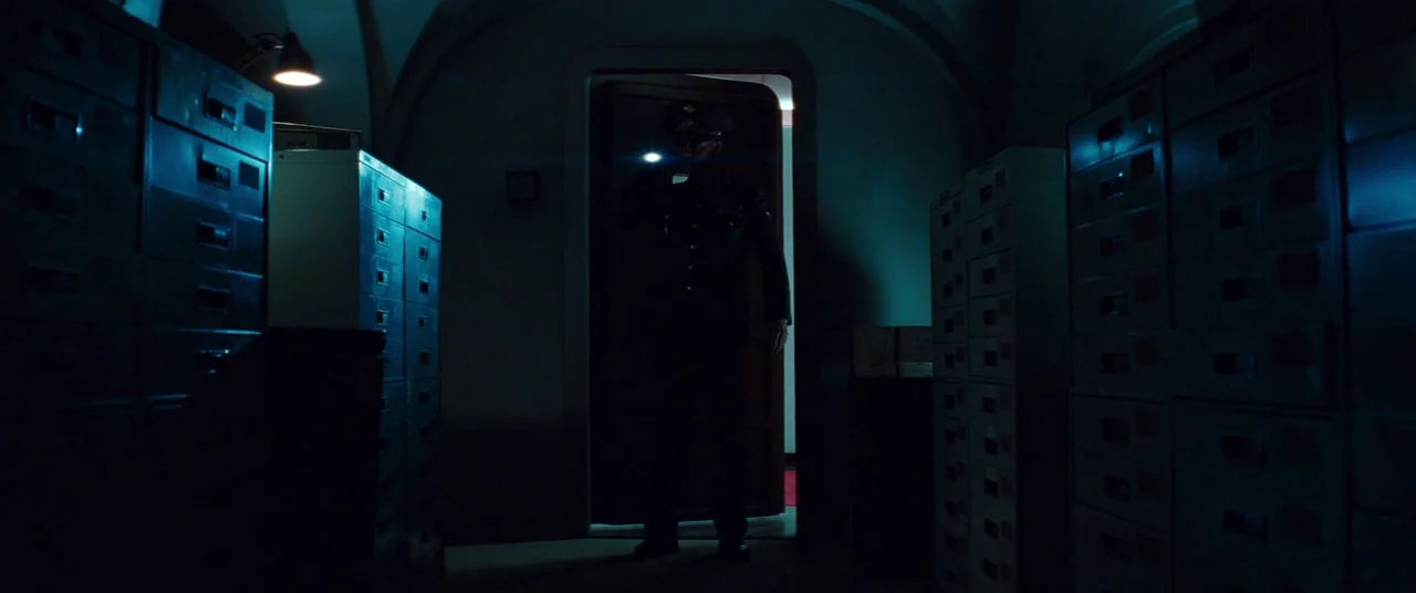 Mission: Impossible – Ghost Protocol (2011) movie still: fullbody — A dark, cramped archival space is filled with tall rows of metal filing…