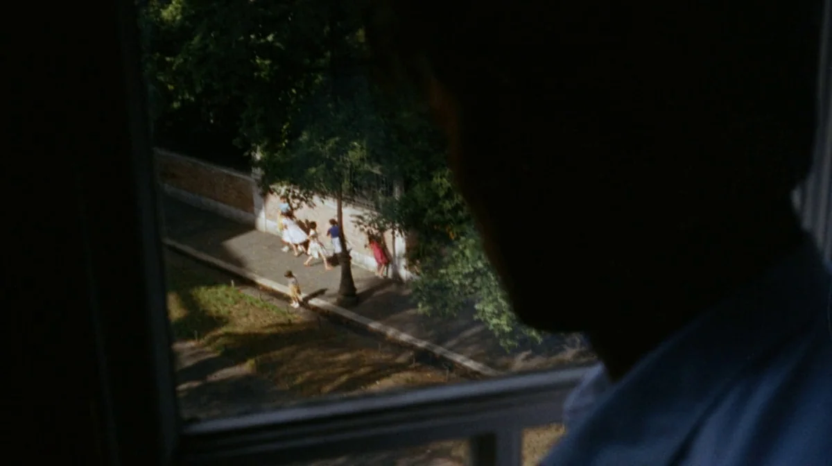 Purple Noon (Plein Soleil) (1960) movie still: wide — A view from an interior window overlooking a sunny tree-lined street with a sidewalk. Four…