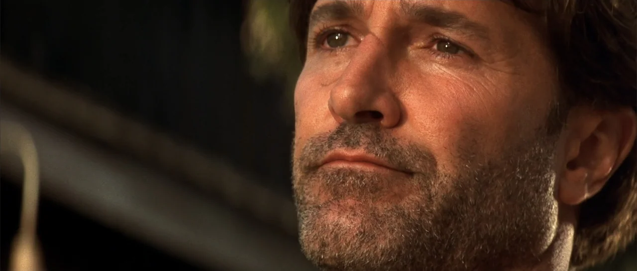 Jeepers Creepers 2 (2003) movie still: closeup — A man stands outdoors bathed in warm sunlight during the late afternoon. He looks off-screen with a…