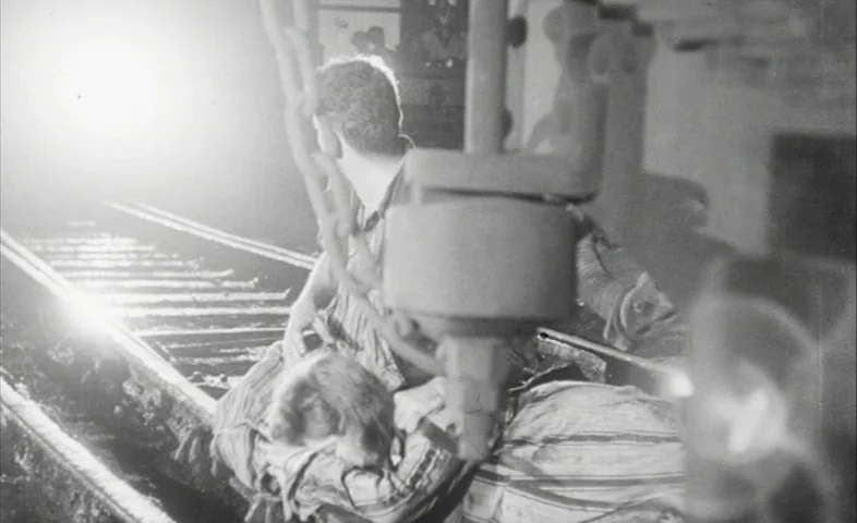Cairo Station (1958) movie still: medium — Two people are positioned on dark railroad tracks directly in front of a light. The individuals face an…