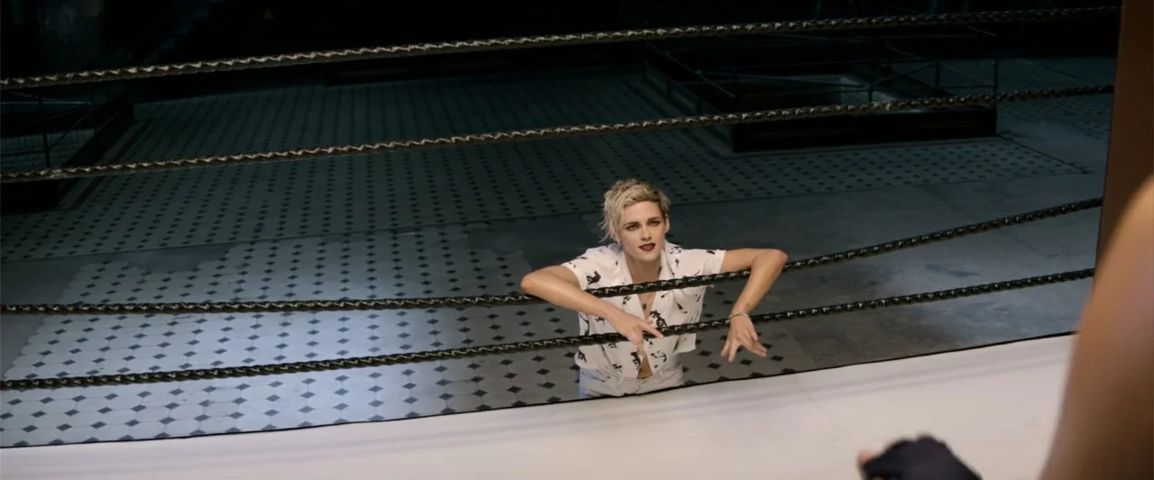 Charlie's Angels (2019) movie still: medium — A spacious indoor facility features a professional boxing ring with black ropes. A woman with short…