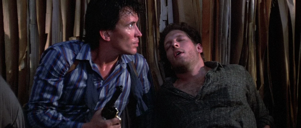 The Adventures of Buckaroo Banzai Across the 8th Dimension (1984) movie still: medium — A dark space filled with hanging vertical strips of paper or…