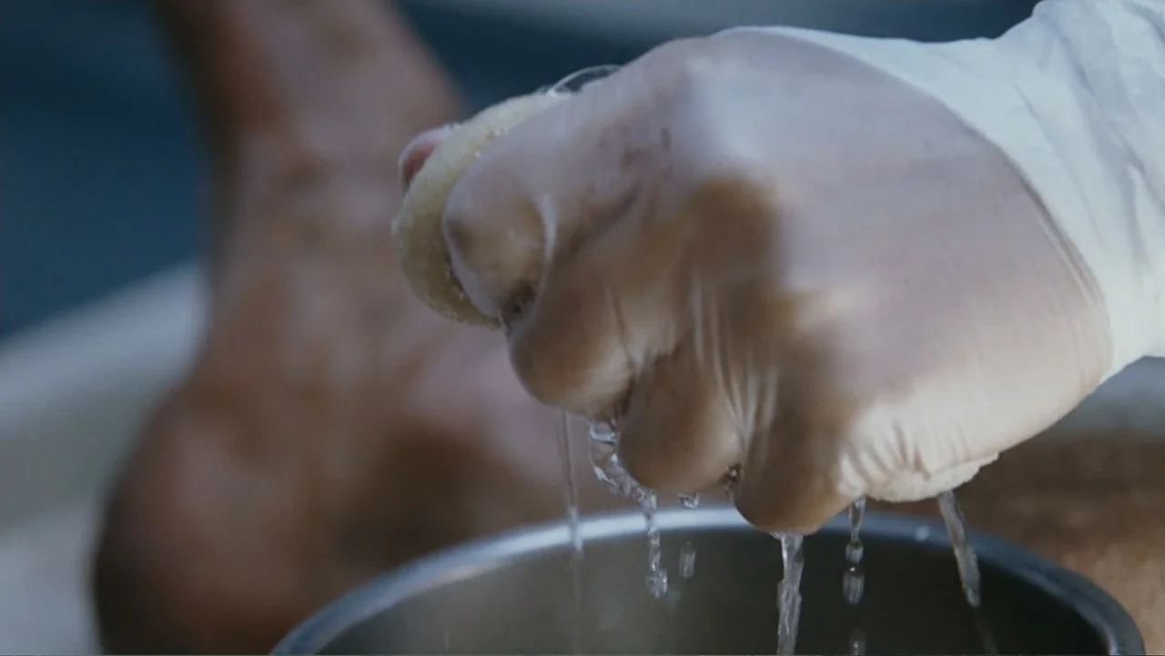 Taking Chances (2011) movie still: closeup — A clinical space with a metal bowl sitting on a flat surface. A person wearing a white medical glove…