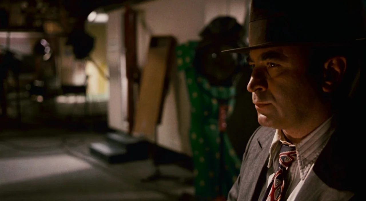 Who Framed Roger Rabbit (1988) movie still: medium — A dark film studio interior filled with production equipment and a patterned green backdrop. A…
