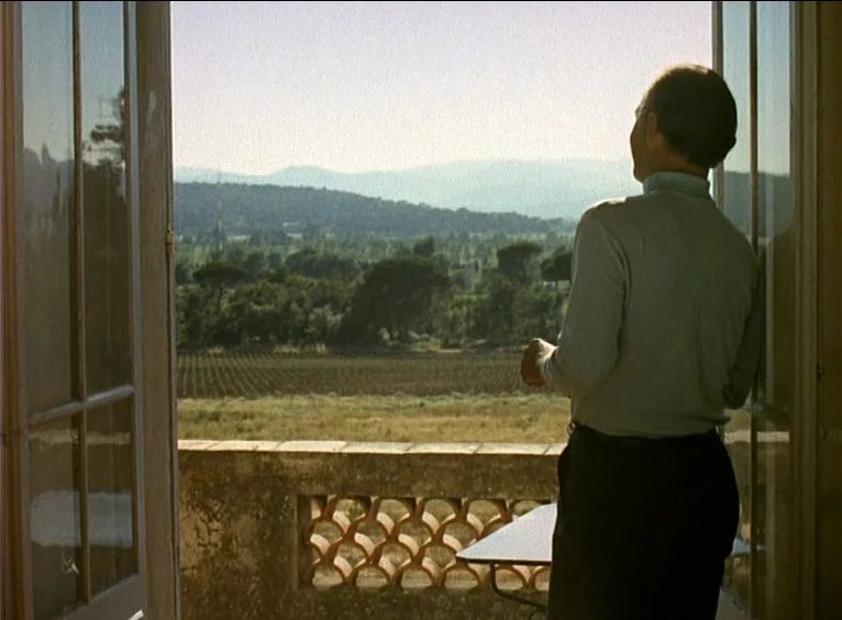 La Collectionneuse (1967) movie still: medium — A stone balcony with an ornate clay brick railing overlooks a wide rural valley. An elderly man…