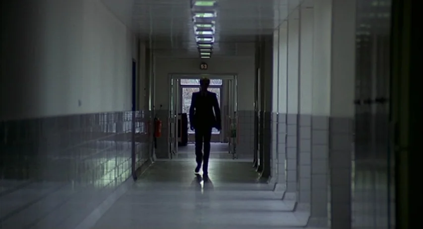 Malpertuis (1971) movie still: wide — A long, symmetrical hospital corridor features tiled walls and rows of overhead fluorescent lights. A…