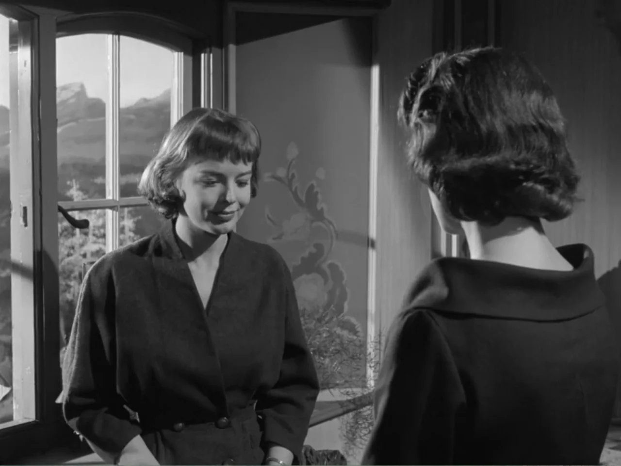 The Crawling Eye (1958) movie still: medium — An interior bedroom setting featuring a window with a view of hills. A woman stands in front of…