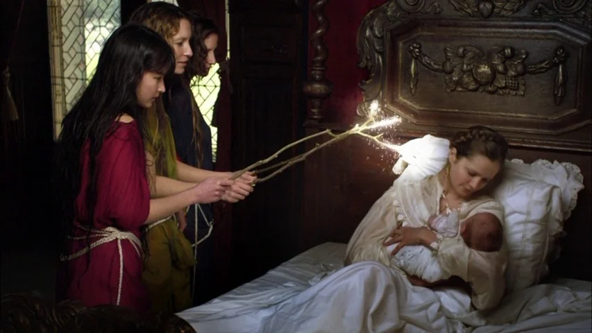 The Sleeping Beauty (2010) movie still: medium — A dark, wood-paneled bedroom features an ornate bed with a high carved headboard. Three women in…