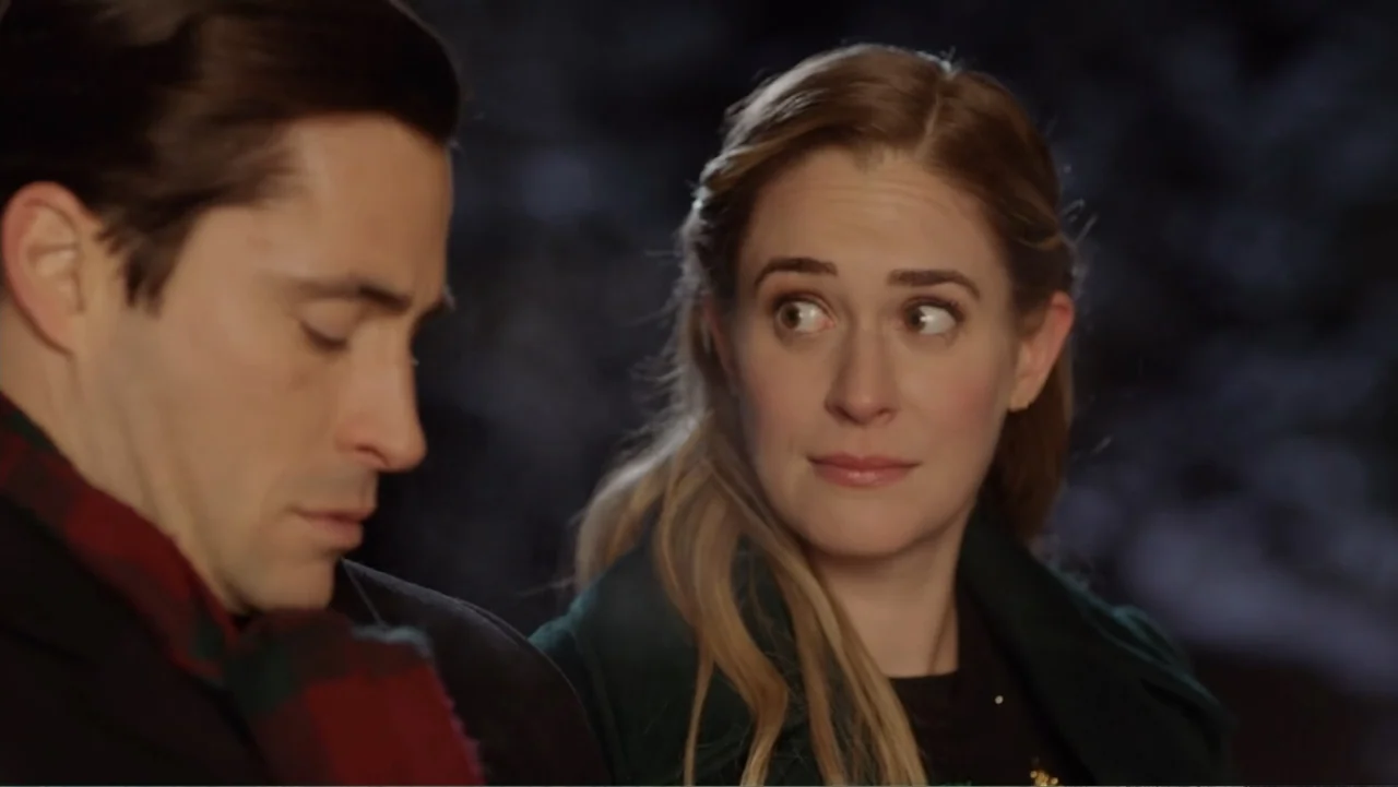 Loving Christmas (2022) movie still: medium — A dark outdoor setting at night frames two people positioned close together in conversation. A woman…