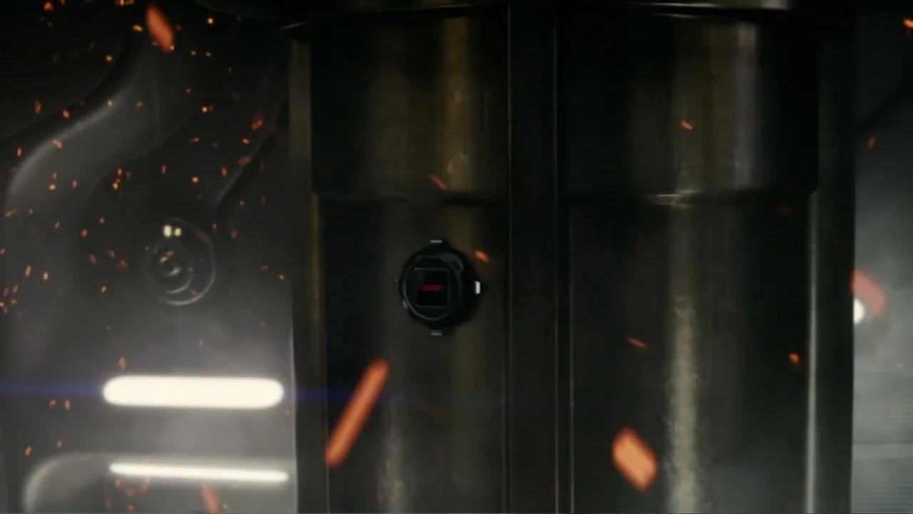 Total Recall (2012) movie still: closeup — A dark industrial metallic structure occupies the frame with a circular interface mounted centrally.…