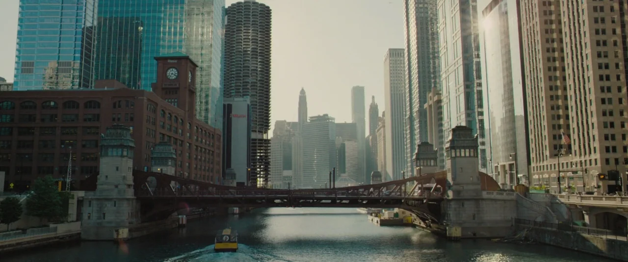 Chi-raq (2015) movie still: establishing — A view of the Chicago River flowing beneath the LaSalle Street Bridge surrounded by skyscrapers. The…
