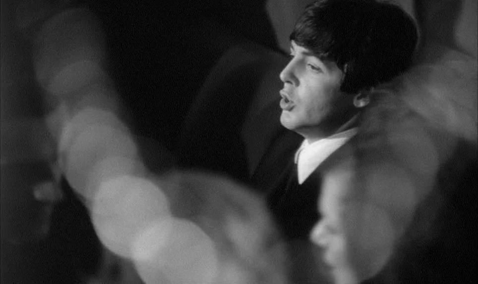 A Hard Days Night (1964) movie still: medium — A dimly lit studio environment with out-of-focus highlights appearing as bokeh in the foreground. A…