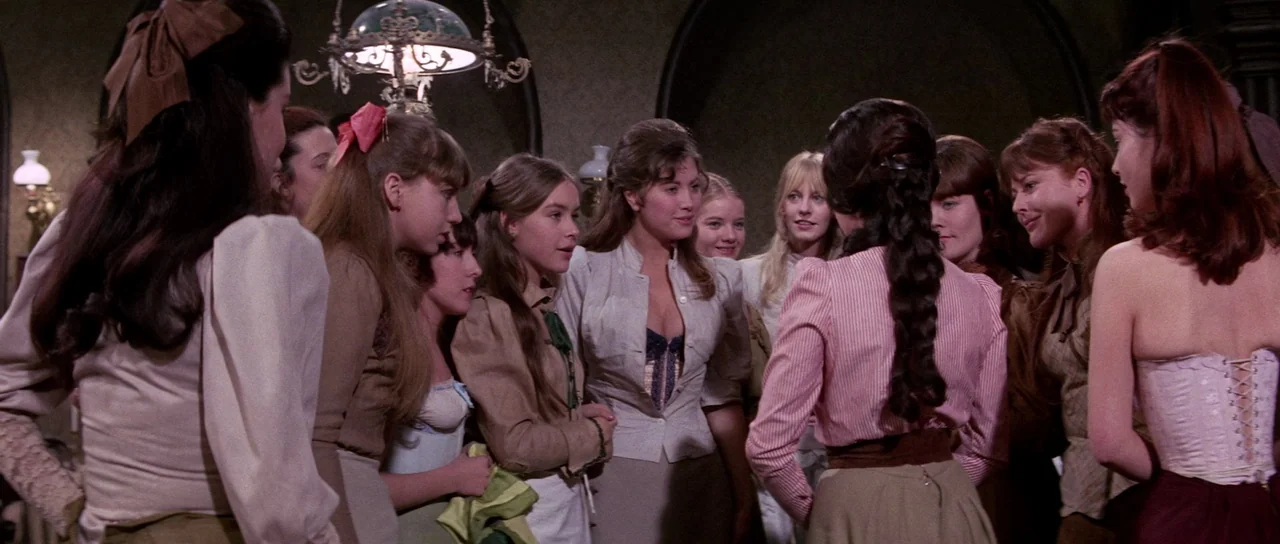 The House That Screamed (1969) movie still: medium — A group of young women in period clothing converse in a dimly lit room. The gathering takes…