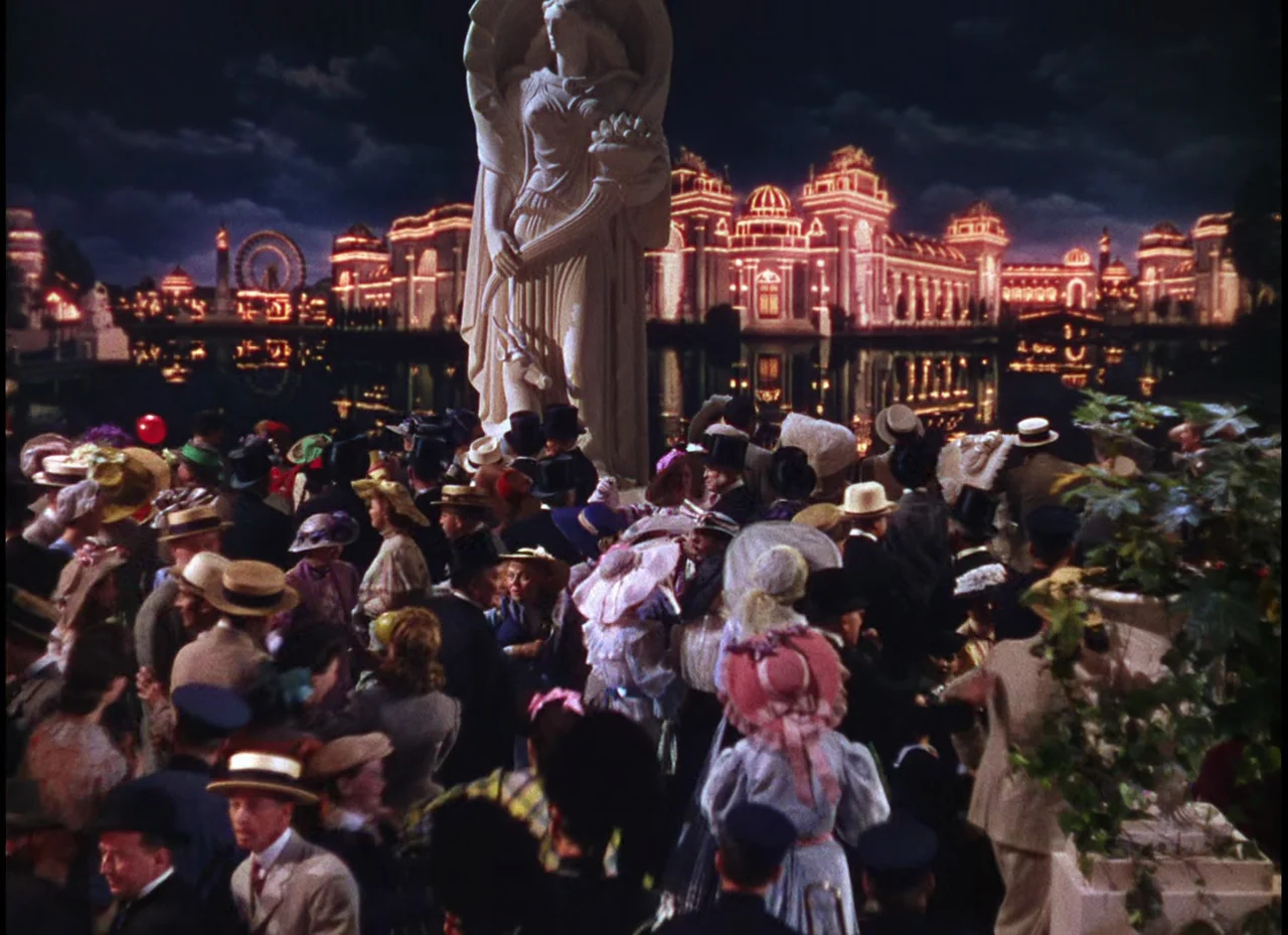 Meet Me In St. Louis (1944) movie still: wide — A large crowd gathered at night before a massive neoclassical statue and illuminated palace. The…