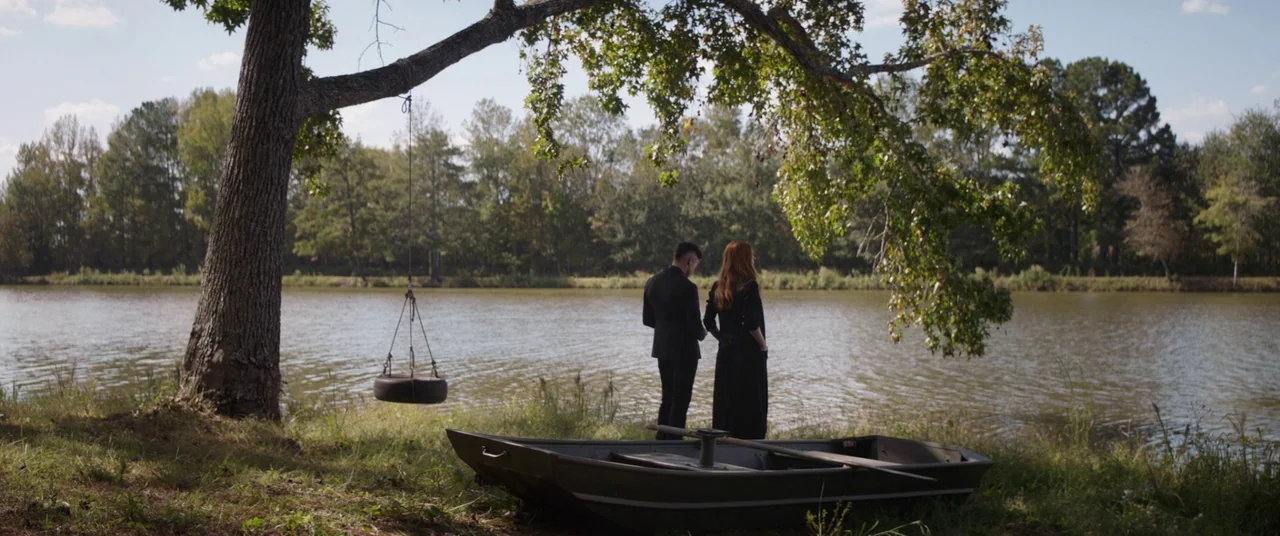 Avengers: Endgame (2019) movie still: wide — A rural lakeshore features a large tree with a tire swing and a boat. A man and a woman stand together…