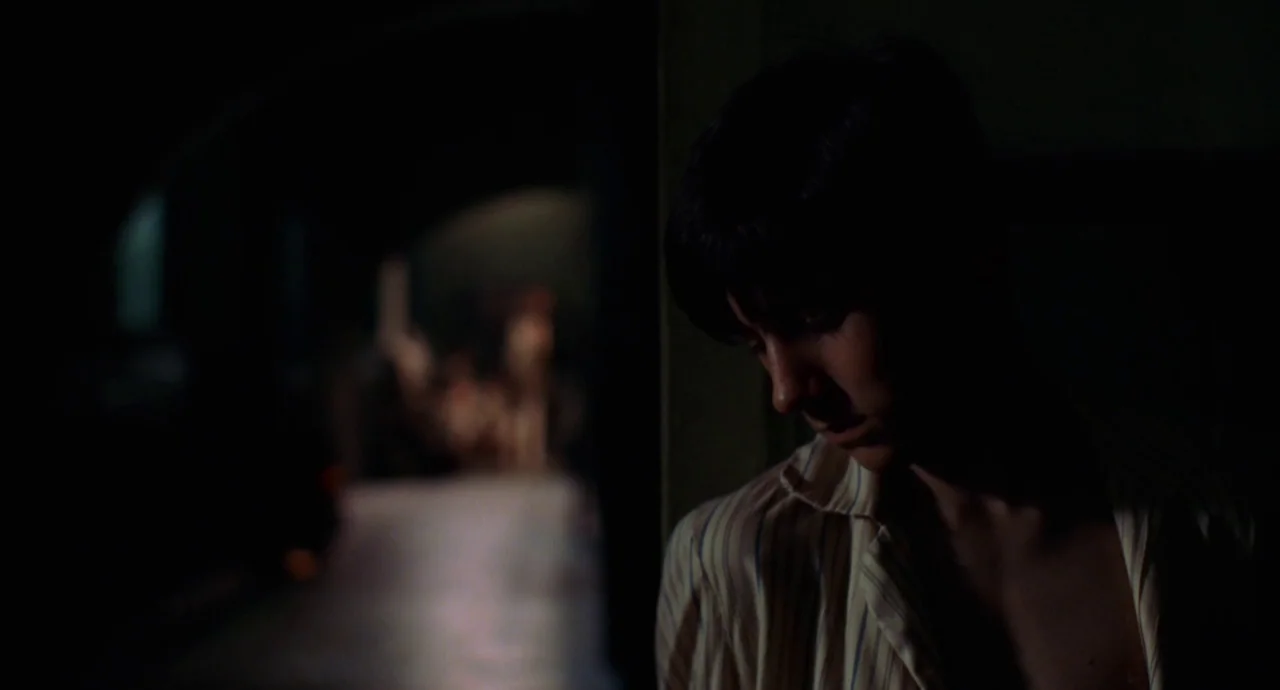 The Devils Backbone (2001) movie still: medium — A dark, narrow passageway contains a young person standing in a dimly lit area. The individual…
