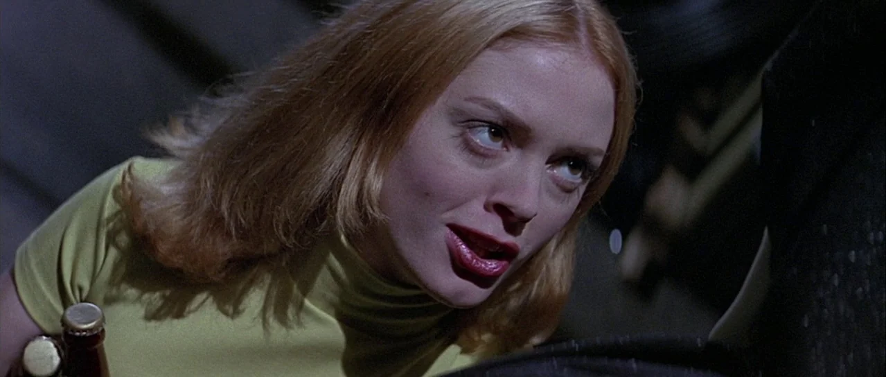 Scream (1996) movie still: closeup — A woman looks up in a dimly lit, dark nighttime outdoor space. She is holding a beer bottle while looking at…