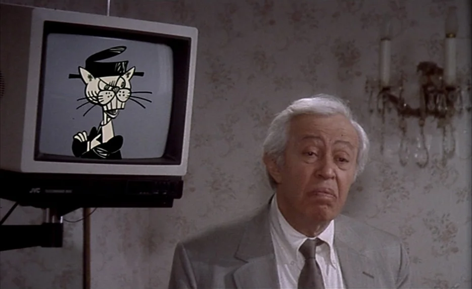 I Want To Go Home (1989) movie still: medium — A domestic space features patterned floral wallpaper and a wall-mounted cathode ray television. An…